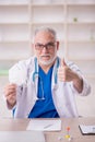 Old male doctor wearing mask in the clinic Royalty Free Stock Photo