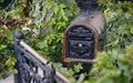 An old domestic wooden and iron mailbox in a front yard Royalty Free Stock Photo