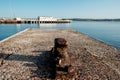 Old dock cleat in Weymouth harbor in the morning. Pier in the horizon Royalty Free Stock Photo