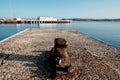 Old dock cleat in Weymouth harbor in the morning. Pier in the horizon