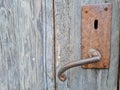 Old rusted door handle on a wooden door Royalty Free Stock Photo