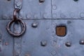 Old door covered with metal plates, painted gray, with a door knocker and a view hole, in Germany Royalty Free Stock Photo