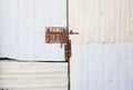 An old door covered in sheet metal and with a rusty iron latch. Royalty Free Stock Photo