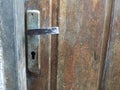 The old door handle is broken and still in use on a wooden door Royalty Free Stock Photo