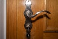 Old door handle with inserted key on a wooden door in the hotel room Royalty Free Stock Photo