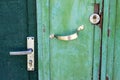 Old door handle and a lock on the blue and turquoise metal vintage door. Texture of cracked paint. Royalty Free Stock Photo