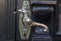 Old door handle. Wooden vintage entrance door with antique door handles in the shape of bird. Selective focus Royalty Free Stock Photo