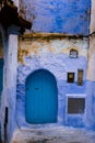 Old door of a house on a street painted blue in the medina of Chefchaouen, Morocco Royalty Free Stock Photo