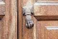 Old door knocker in shape of hand and wooden door background Royalty Free Stock Photo