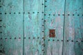 Old door with metal ornaments on bluish green painted natural wood Royalty Free Stock Photo