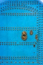 Old door with golden nails, on the house on a blue painted street in the medina of Chefchaouen, Morocco Royalty Free Stock Photo