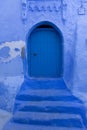 Old door of a house on a street painted blue in the medina of Chefchaouen, Morocco Royalty Free Stock Photo