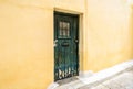 Old door of residential building in Plaka district, Athens, Greece. Traditional house with yellow wall and grunge door on vintage Royalty Free Stock Photo