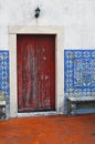 The old door and wall is lined with tiled azulejo on the terrace