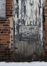 Old wooden door in a red crumbling brick wall Royalty Free Stock Photo