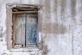 Old double closed wooden shutters. Rusty hinges on peeled planks,  stones keep the window shut. Wall blank and faded. Copy space Royalty Free Stock Photo