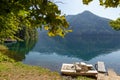 Old double place wooden catamaran for rest stays near the shore of the Lake Ritsa, Abkhazia, Georgia Royalty Free Stock Photo