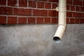 Old drain pipe on the brown brick wall. Downspout Royalty Free Stock Photo