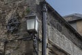 Old drain pipe and carriage light attached to a wall Royalty Free Stock Photo