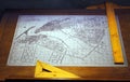 Old drawing of the city of Dubai in the 60s placed on an architectÃ¢â¬â¢s table with wooden geometry tools.