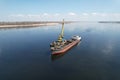 An old dry-cargo ship is anchored under sand loading on the Volga