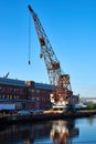 Old dry dock crane in the Brooklyn Navy Yard creates a reflection in the water on a clear blue late summer day