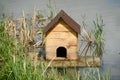 Old duck house made of wood on a raft on a pond Royalty Free Stock Photo