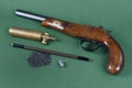 Old duel pistol with an accessory on green Royalty Free Stock Photo