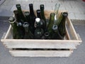 Old dusty bottles in a wooden crate.