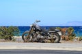 Old dusty motorcycle standing on the side of the road