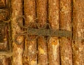 Old dusty rustic weathered iron hinge on wooden door