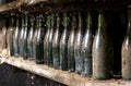 Old dusty wine bottles on a cellar shelf