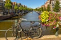 Old Dutch bike against the railing of a bridge over a canal in Amsterdam, Holland