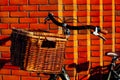 Old dutch bike wooden bicycle basket wall red orange wisker big vintage sun light brick Royalty Free Stock Photo