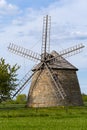 Old Dutch windmill. Built in 1880-1885. Standing on a green meadow with blue sky and clouds