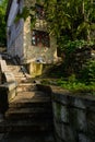 Aged house by hillside stone stairway in sunny spring morning