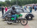 Old motorbike and veteran retro historic famous car VW Beetle parked