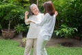 An old elderly Asian woman and dance in the backyard with her daughter.  Concept of happy retirement With care from a caregiver Royalty Free Stock Photo