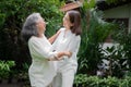 An old elderly Asian woman and dance in the backyard with her daughter.  Concept of happy retirement With care from a caregiver Royalty Free Stock Photo