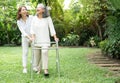 An old elderly Asian woman uses a walker and walking in the backyard with her daughter.  Concept of happy retirement With care Royalty Free Stock Photo
