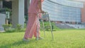 An old elderly Asian woman uses a walker and walking in the backyard in hospital. Physical therapy, Rehabilitation and senior Royalty Free Stock Photo