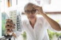 Old elderly holding medicine pills in her hands,female patient touch her head suffer from headache,high blood pressure,painful,