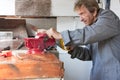 Old elderly man sawing in workshop shed Royalty Free Stock Photo