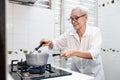 Old elderly people cooking vegetables soup,mixing and heating the ingredients,healthy food,good cook,asian senior woman standing