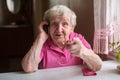 Old happy elderly woman talks on a mobile phone.