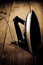 Old electric iron on the wooden background