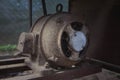 Old electric motor powering a table saw bench saw. Vintage industrial equipment concept. Rusty and dirty electric engine power