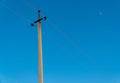 Old electric pole with wires used for electricity traffic with clear blue sky. Power electric pole