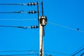 An old electric wooden pole with a lamp and electricity cables hanging on. Natural light Royalty Free Stock Photo