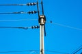 An old electric wooden pole with a lamp and electricity cables hanging on. Natural light Royalty Free Stock Photo